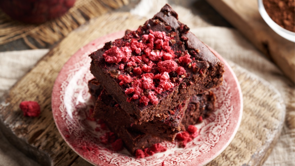 Two pieces of oatmeal chocolate cake stacked on top of each other on a plate.