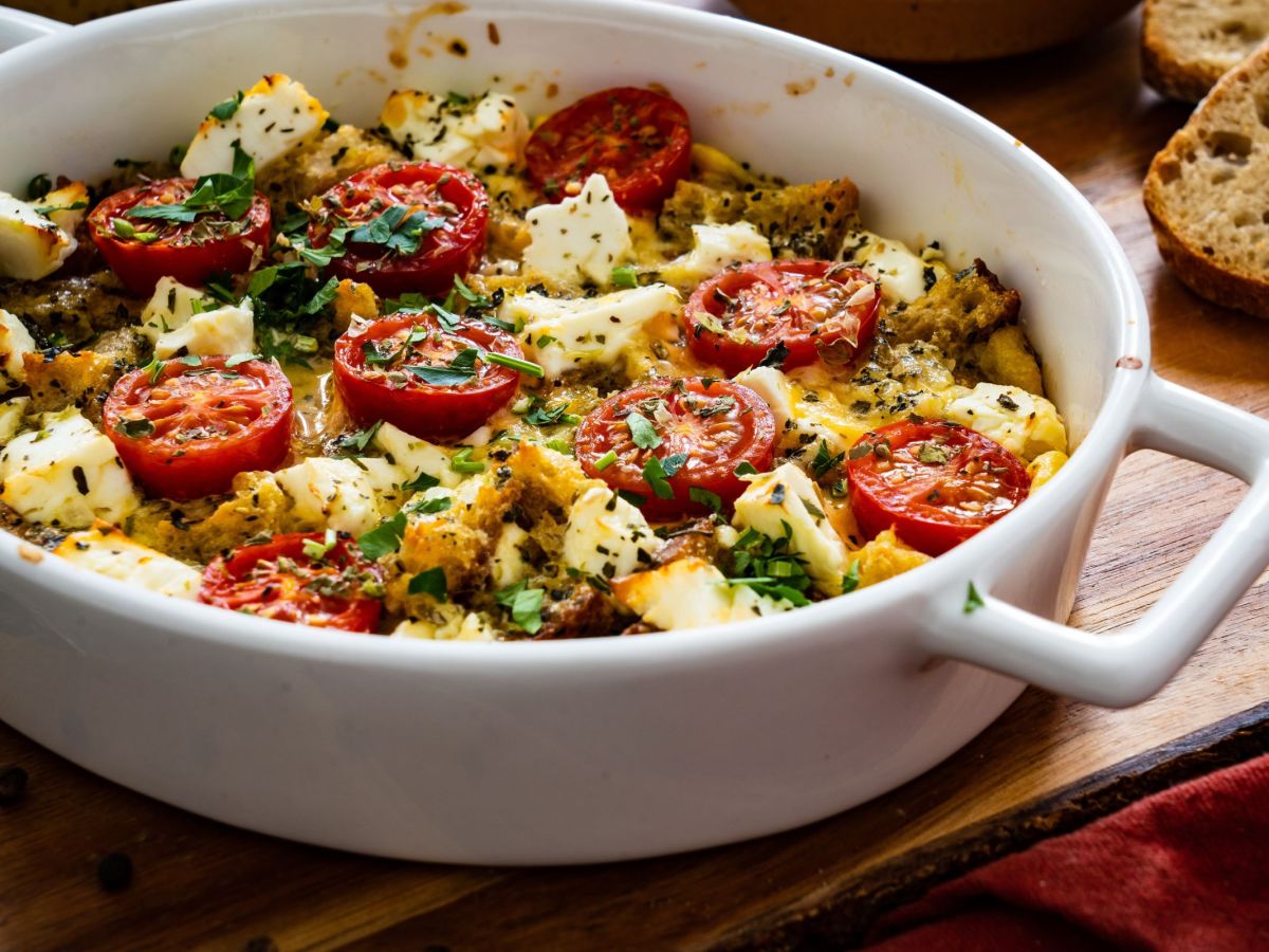 Feta and tomato bake, baked in a white baking dish.