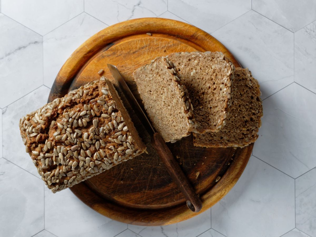 A sliced 5-minute bread lies on a bed. Some slices of bread are visible, next to it is a knife.