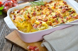 Carbonara potato casserole with bacon in a baking dish, close-up.