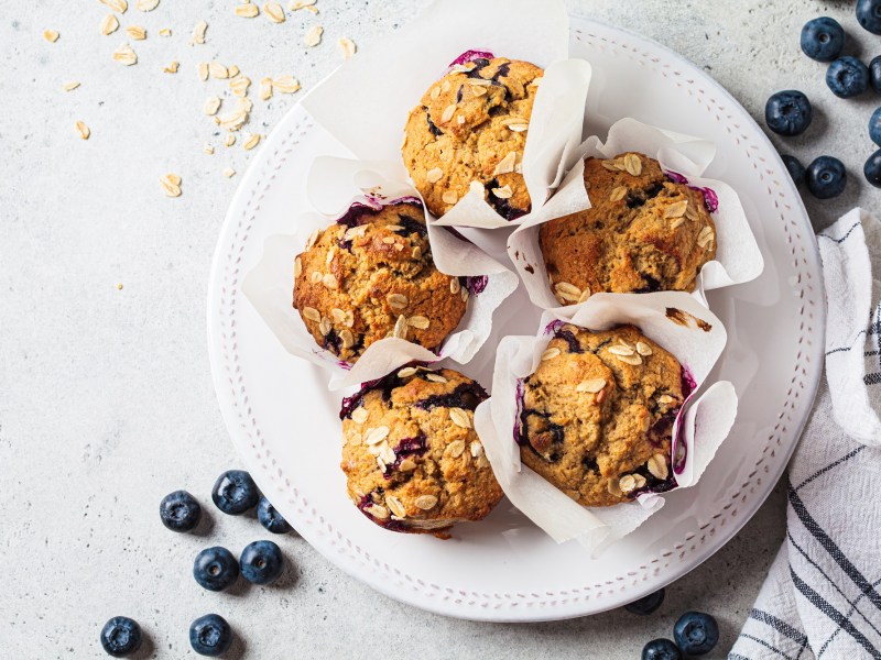 Vegan oatmeal, banana, blueberry muffins on a gray background, top view. Plant based dessert.