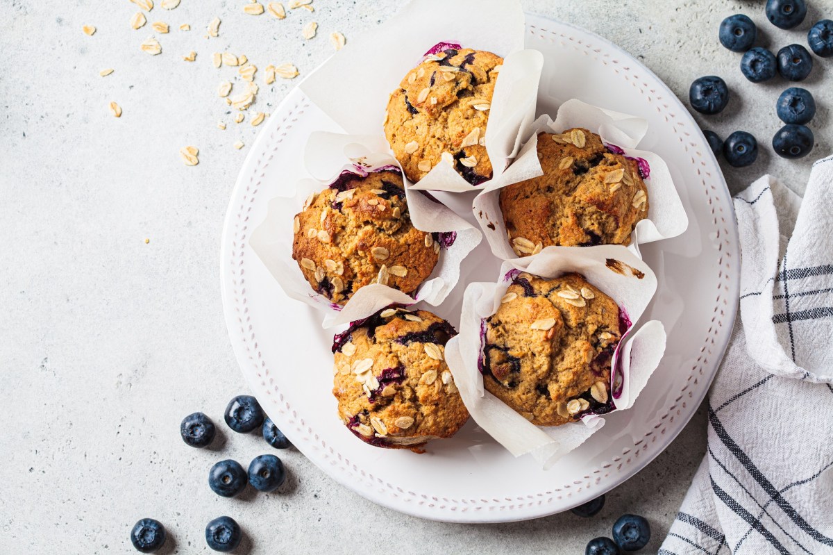 Vegan oatmeal, banana, blueberry muffins on a gray background, top view. Plant based dessert.