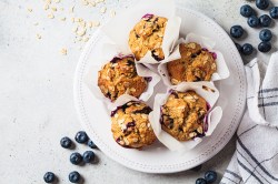 Vegan oatmeal, banana, blueberry muffins on a gray background, top view. Plant based dessert.