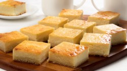 A plate of golden yellow hot milk slices on a table.