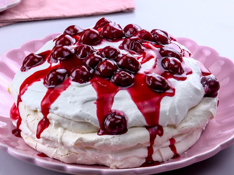 Pink plate with pavlova with cherries