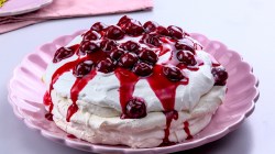 Pink plate with pavlova with cherries