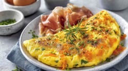 A carrot omelette with ham on a plate.