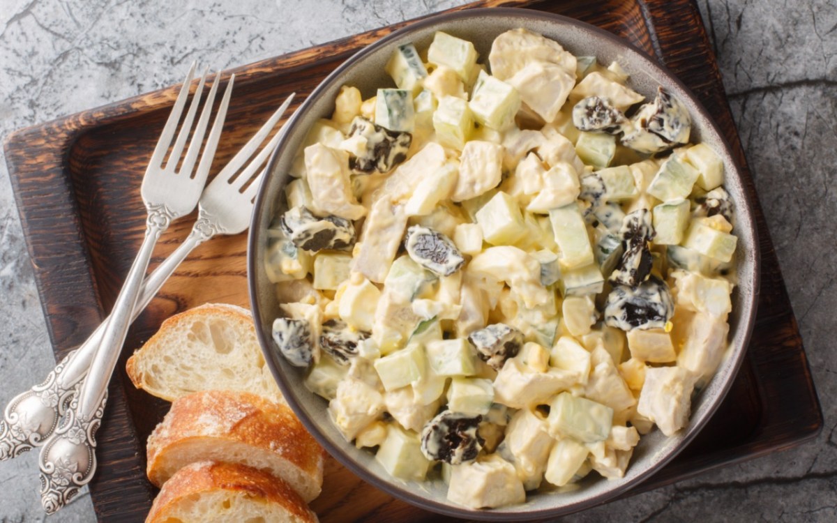 A bowl of creamy chicken salad with prunes.