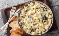 A bowl of creamy chicken salad with prunes.