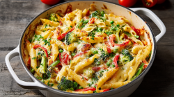 Pasta Primavera Casserole in an enamel pot, topped with cheese.