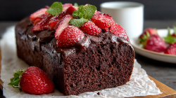 Strawberry chocolate loaf cake, garnished with strawberries and mint leaves.