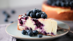 A piece of blueberry sour cream cheesecake.