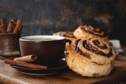 Coffee Cinnamon Rolls next to a coffee cup.