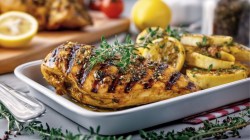 Grilled lemon chicken on a square plate.