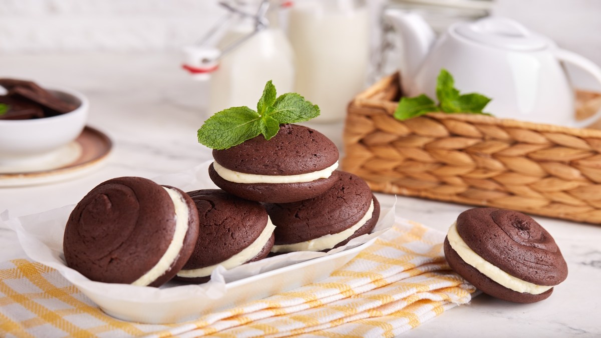 Several whoopie pies on a plate, surrounded by some tableware.