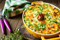 Yellow baking dish with a potato and zucchini casserole.